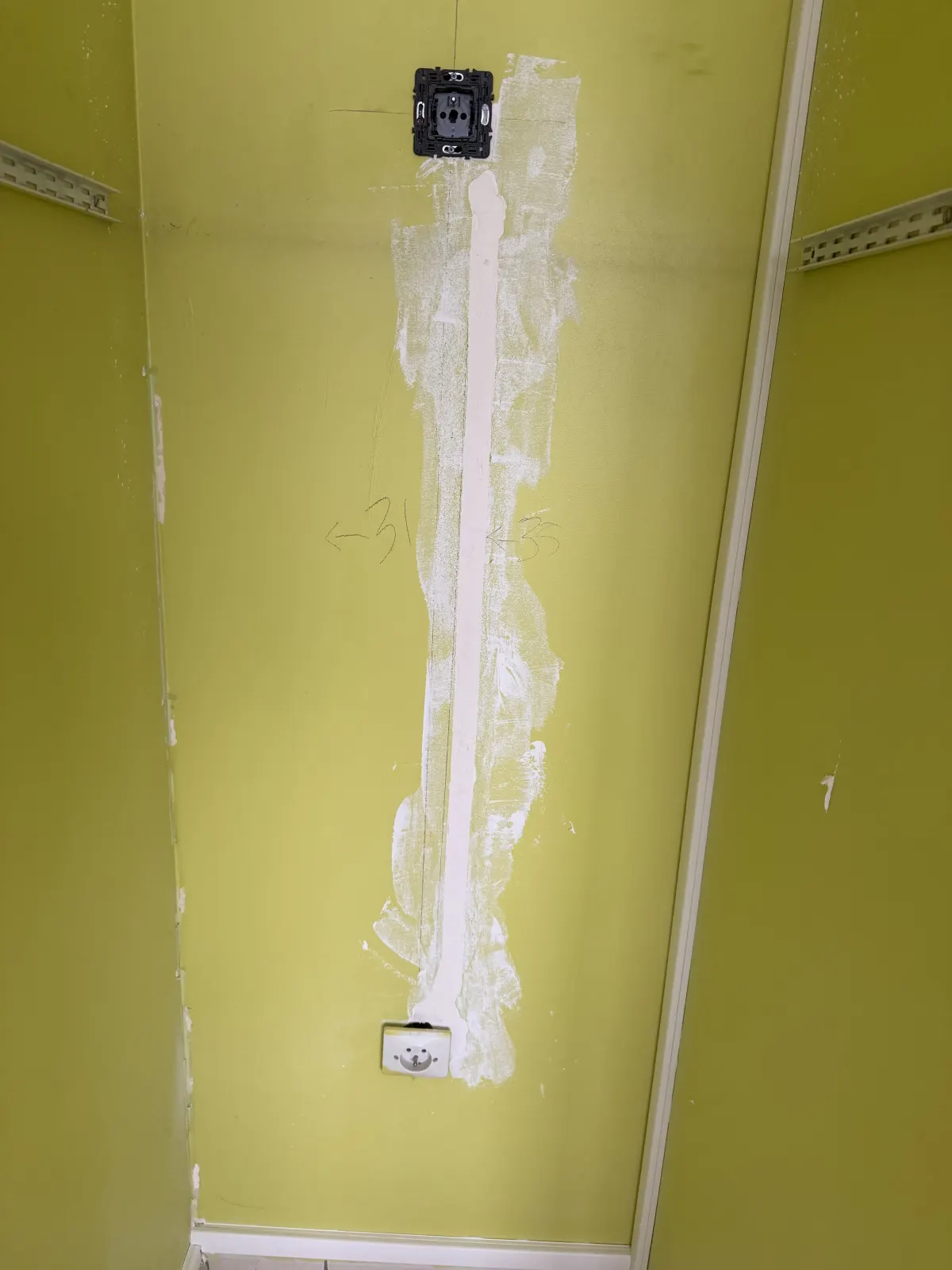 Prise ajoutée en haut d'un placard, reliée à la prise du bas par une saignée verticale rebouchée au plâtre