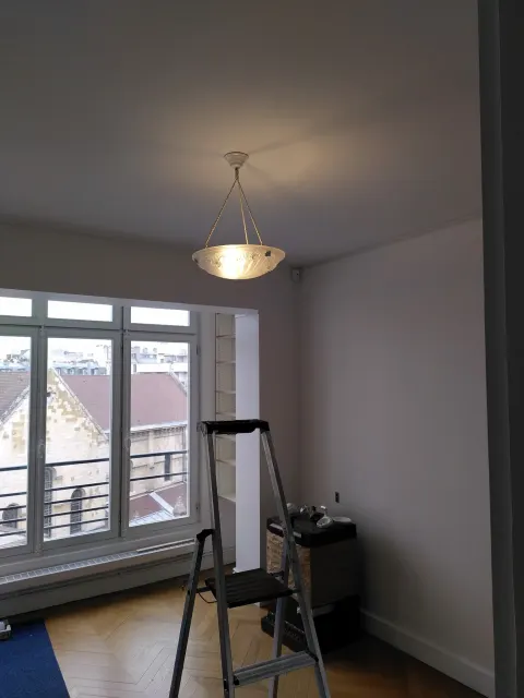 Pose d'une suspension art-déco dans un séjour parisien