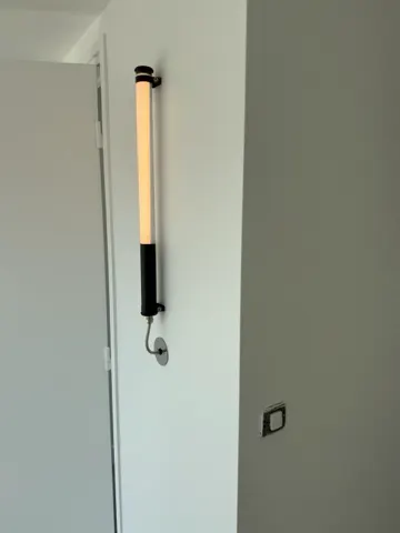 Luminaire tubulaire vertical posé le long d'une porte